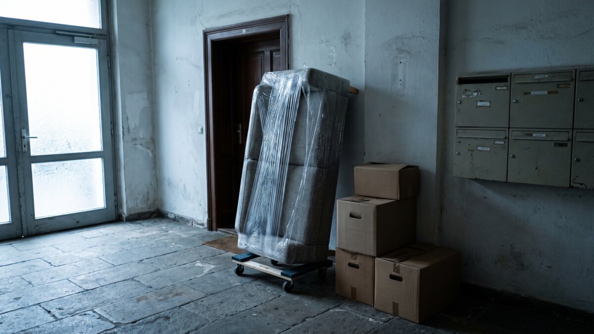 Verpacktes Sofa auf einem Möbelroller im Eingangsbereich