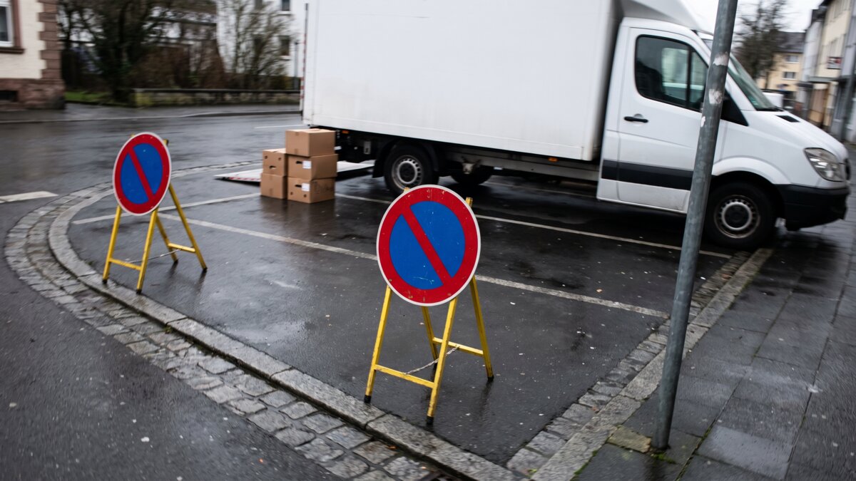 Zwei mobile Halteverbotsschilder vor einem geparkten Umzugswagen