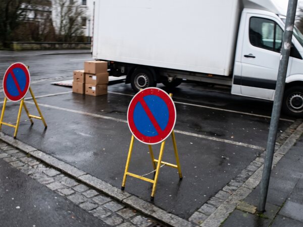 Zwei mobile Halteverbotsschilder vor einem geparkten Umzugswagen