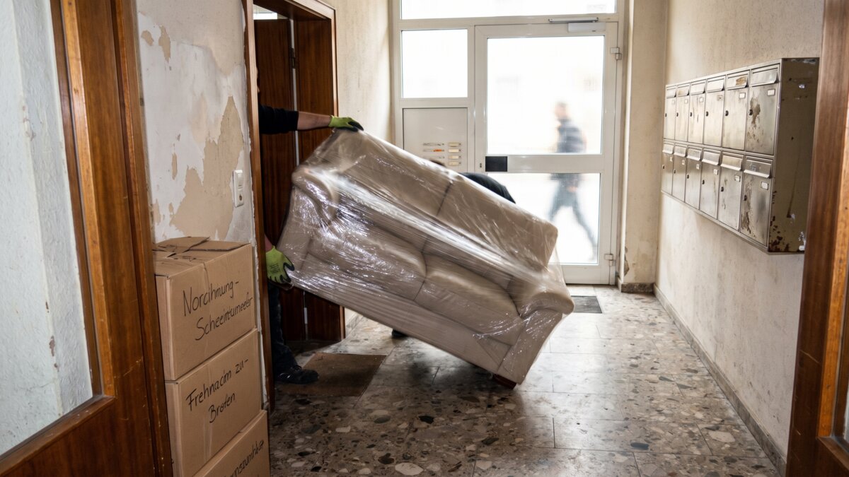 Eingepacktes Sofa wird durch einen Hausflur getragen